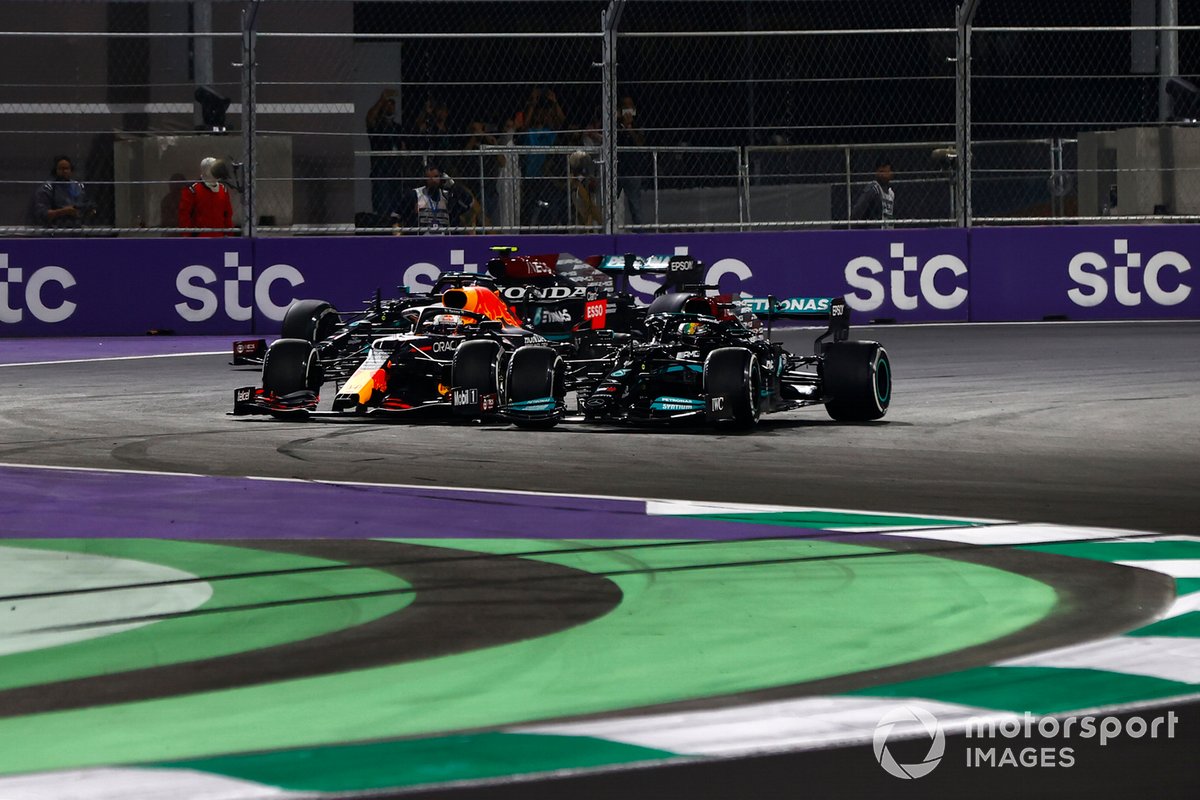 Max Verstappen, Red Bull Racing RB16B, and Lewis Hamilton, Mercedes W12, battle at the restart