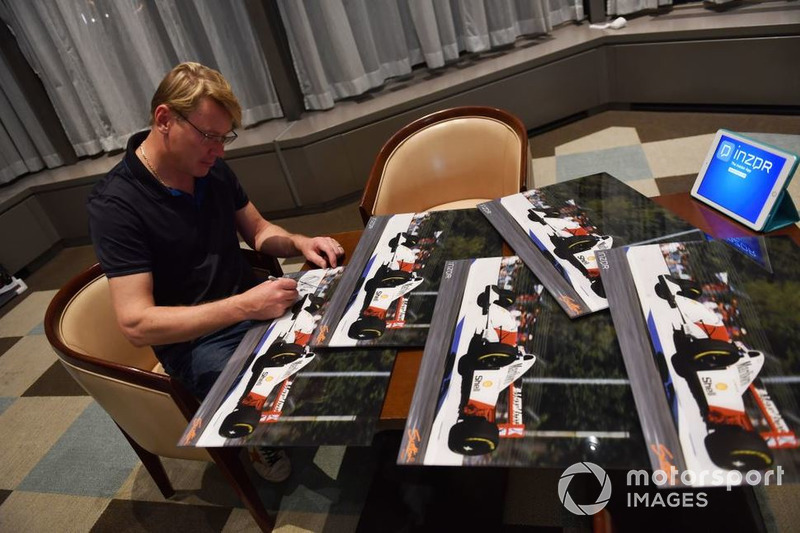 Mika Hakkinen firma las fotos de su vuelo en la práctica del GP de Australia de 1993.