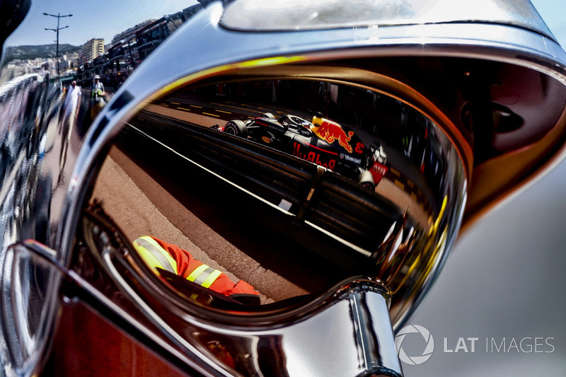 A reflection of the Daniel Ricciardo Red Bull Racing RB14 in the visor of a fire marshal