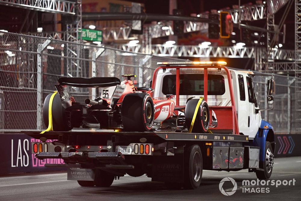 El coche de Carlos Sainz, Ferrari SF-23, regresa a boxes tras los daños causados por una tapa de alcantarilla