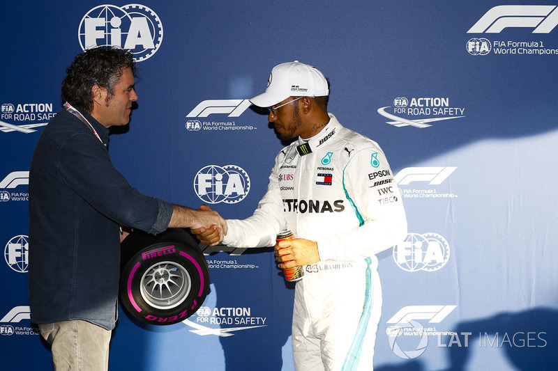 Lewis Hamilton, Mercedes AMG F1, signs a miniature Pirelli tyre after taking pole position