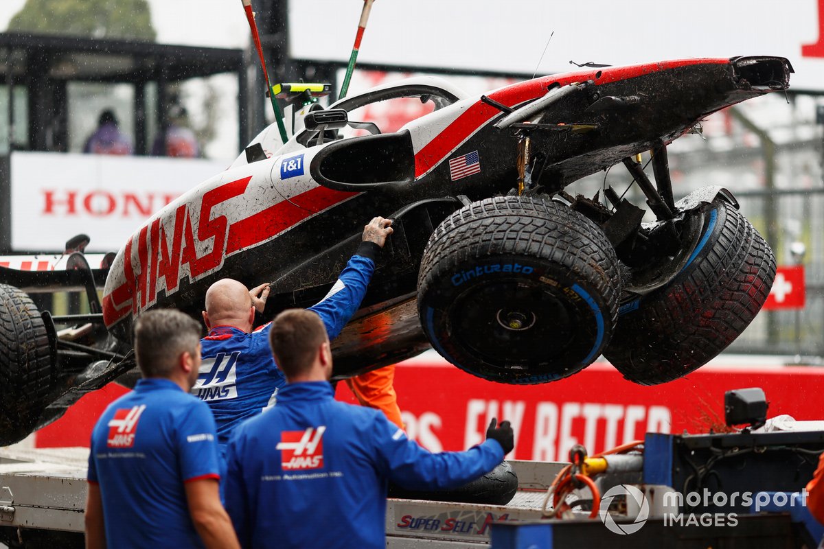Los mecánicos descargan el coche dañado de Mick Schumacher, Haas VF-22, de una plataforma tras la FP1 de Suzuka