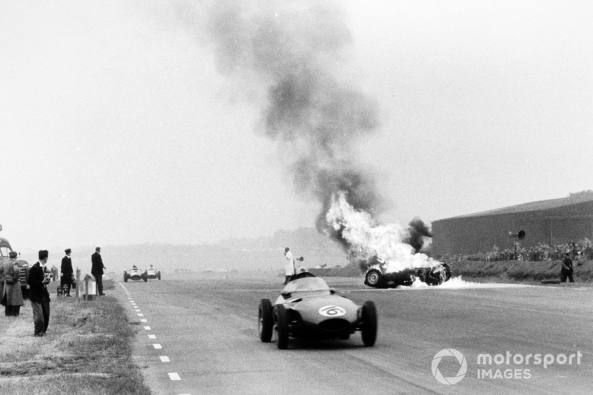 El BRM P25 de Tony Brooks se quema después de haberse estrellado mientras Harry Schell, Vanwall VW2 pasa por el accidente