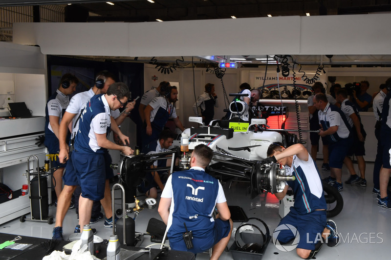 Mechanics work on the car of Felipe Massa, Williams FW40 in the garage
