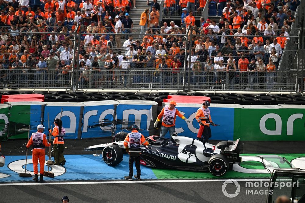 Los oficiales de pista asisten al coche dañado de Daniel Ricciardo, AlphaTauri AT04