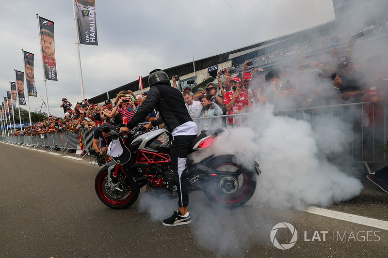 Lewis Hamilton, Mercedes AMG F1 arrives on his MV Agusta Dragster RR LH44 Limited Edition motorbike and performs a burn out for the fans