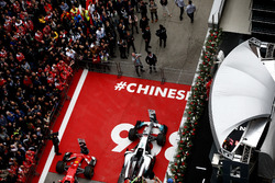 Lewis Hamilton, Mercedes AMG, and Sebastian Vettel, Ferrari, spray Champagne on the podium