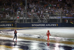 Max Verstappen, Red Bull Racing and Kimi Raikkonen, Ferrari walk on track after colliding and crashing out at the start of the race