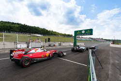 Kimi Raikkonen, Ferrari SF16-H en Nico Rosberg, Mercedes AMG F1 W07 Hybrid koemn de pitstraat uit