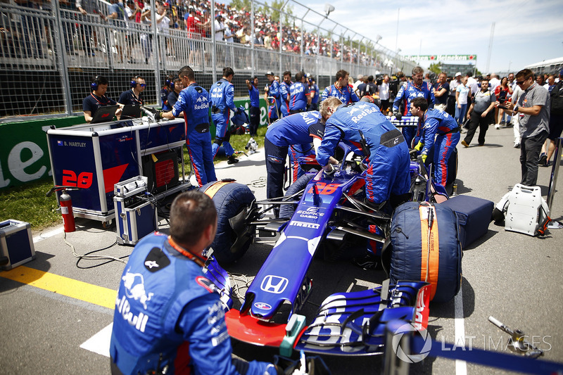 Mecánicos trabajan en el Toro Rosso de Brendon Hartley en la parrilla