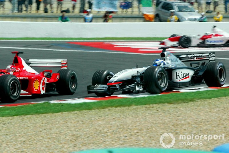Kimi Raikkonen, McLaren Mercedes MP4/17 runs wide, Michael Schumacher, Ferrari F2002 pass