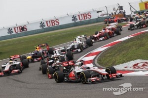 Jenson Button, McLaren Mercedes leads Kimi Raikkonen, Lotus at the start of the race