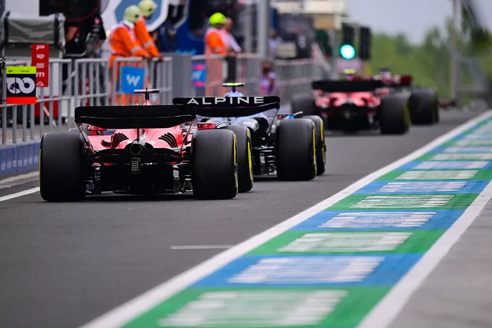 Pierre Gasly, Alpine A523, Charles Leclerc, Ferrari SF-23, in the pit lane