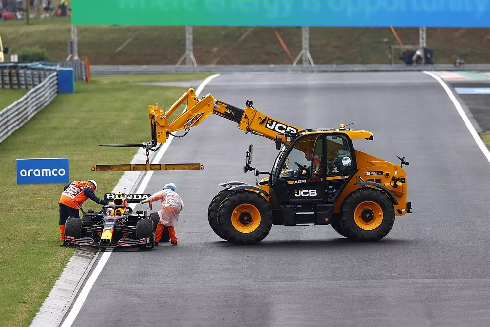 Los oficiales de pista retiran el coche dañado de Sergio Pérez, Red Bull Racing RB16B