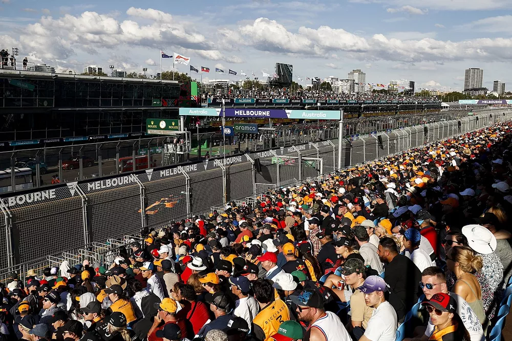 Los aficionados siguen la carrera desde las tribunas desde las tribunas mientras pasa Daniel Ricciardo, McLaren MCL36