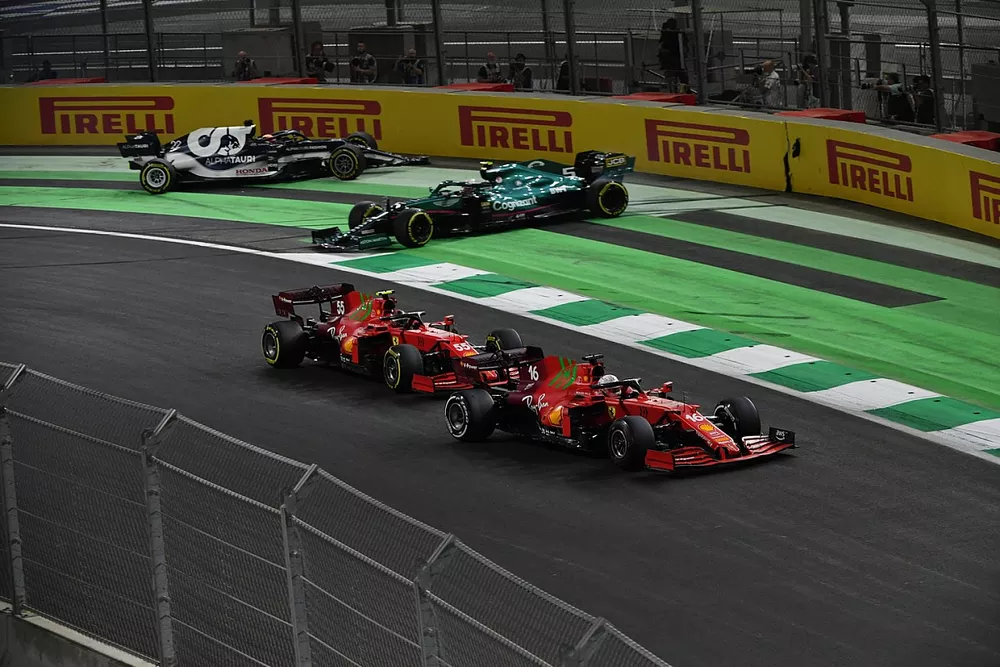 Charles Leclerc, Ferrari SF21, Carlos Sainz Jr., Ferrari SF21, as they pass Sebastian Vettel, Aston Martin AMR21, and Yuki Tsunoda, AlphaTauri AT02