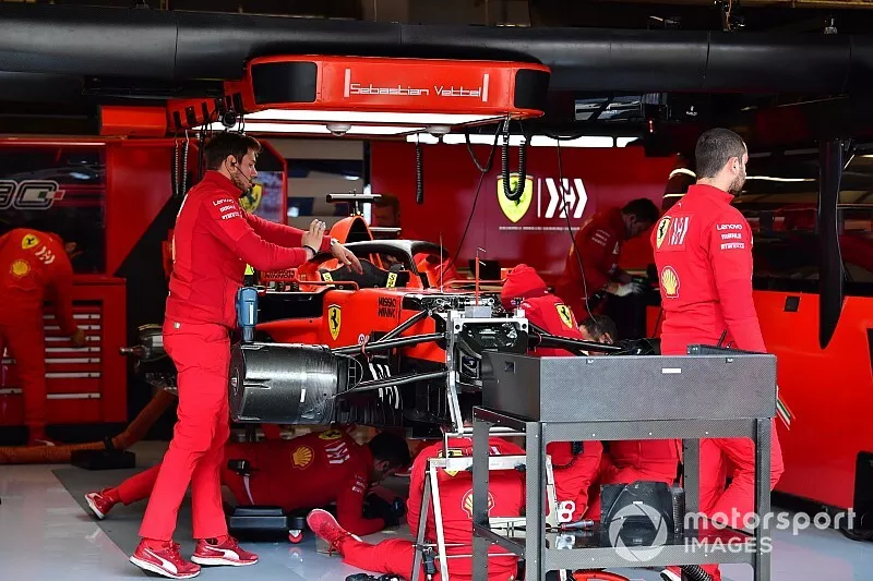 Les m&eacute;caniciens travaillent sur la voiture de Sebastian Vettel, Ferrari SF90