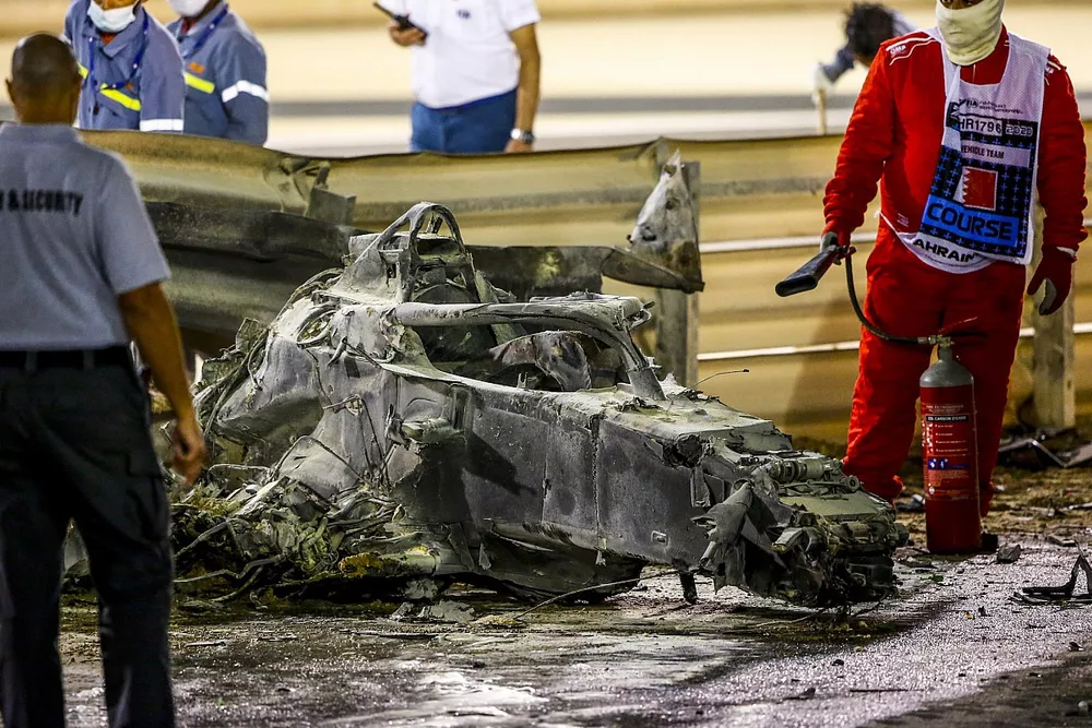 Marshals deal with the wreckage after a huge crash for Romain Grosjean, Haas VF-20, on the opening lap