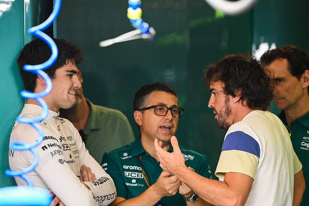 Lance Stroll, Aston Martin, habla con su nuevo compa&ntilde;ero de equipo Fernando Alonso, Aston Martin, ante la mirada de Pedro de la Rosa