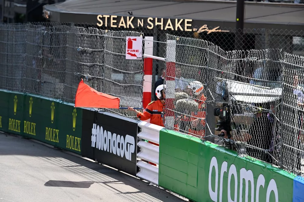 A marshal waves the red flag after a crash invloving Sergio Perez, Red Bull Racing, Kevin Magnussen, Haas F1 Team, and Nico Hulkenberg, Haas F1 Team, on the opening lap