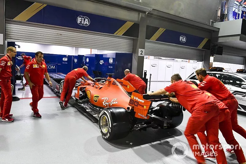 Ferrari SF90 being pushed into the scrutineering bay by Ferrari mechanics