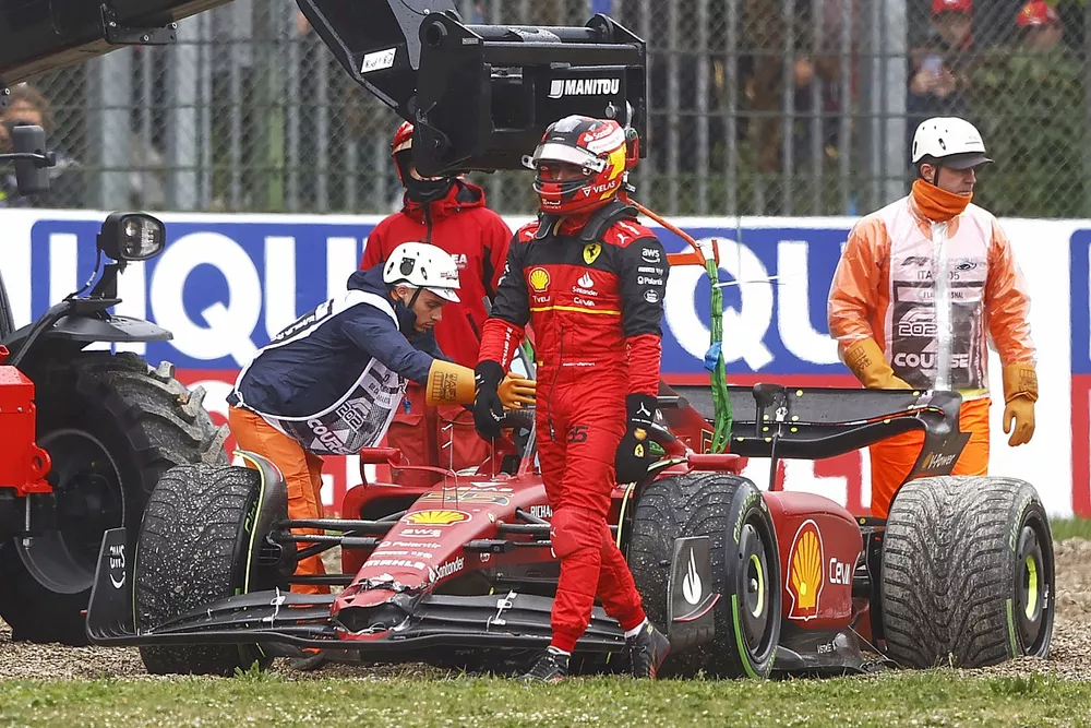 Marshals assist Carlos Sainz Jr., Ferrari F1-75, in the gravel