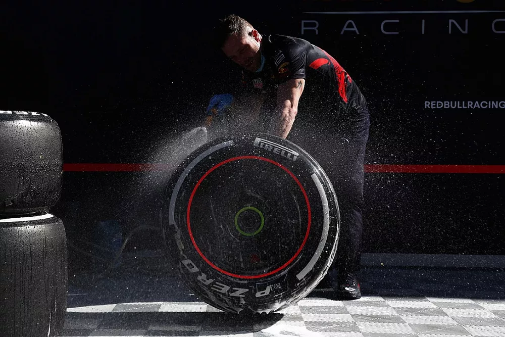 Red Bull Racing mechanic washes tyres in the paddock