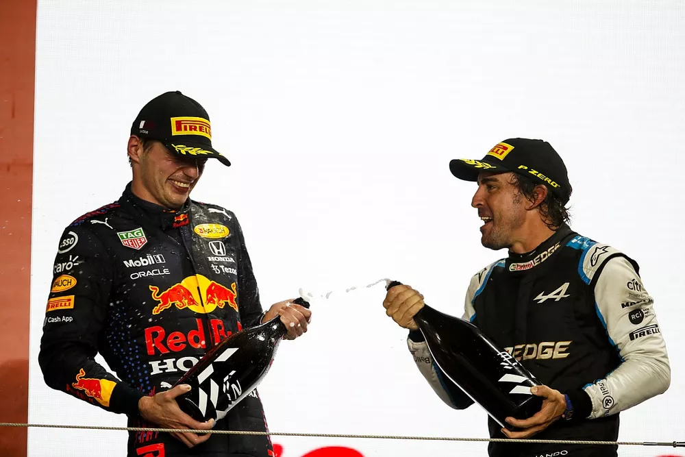Max Verstappen, Red Bull Racing, 2nd position, and Fernando Alonso, Alpine F1, 3rd position, celebrate on the podium with Rose Water