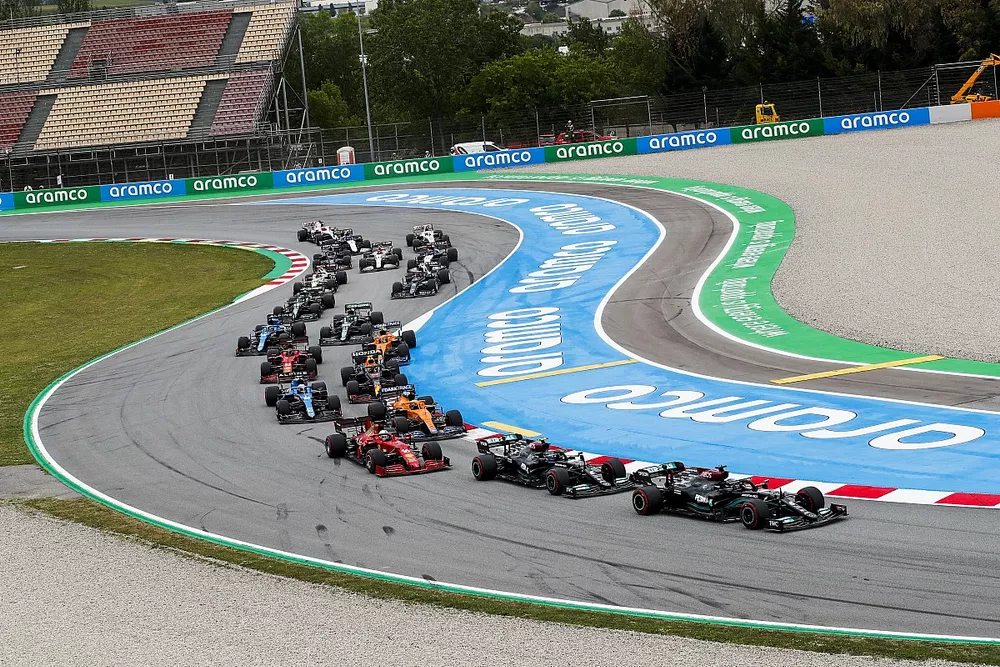 Lewis Hamilton, Mercedes W12, Valtteri Bottas, Mercedes W12, Charles Leclerc, Ferrari SF21, Daniel Ricciardo, McLaren MCL35M, Esteban Ocon, Alpine A521, and the remainder of the field on the opening lap