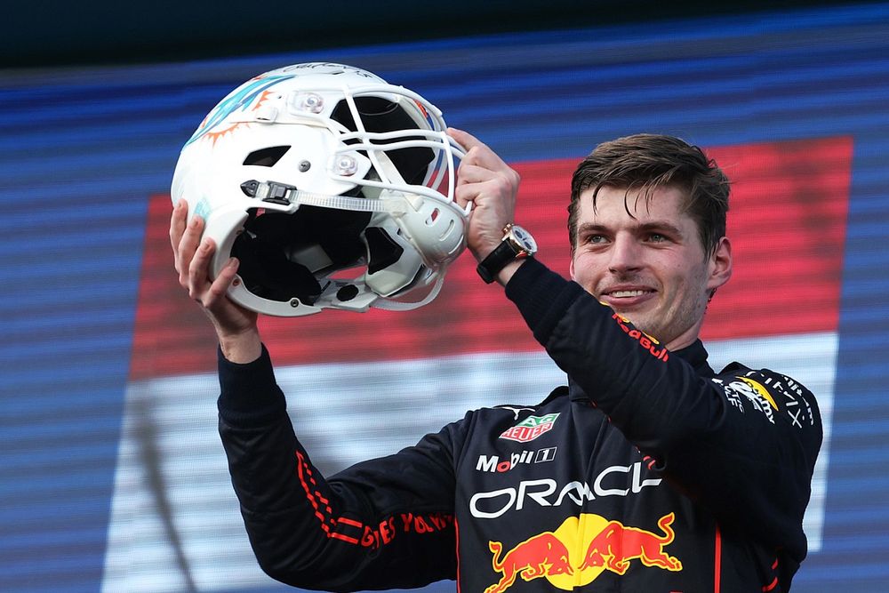 Max Verstappen, Red Bull Racing, 1ª posición, recibe un casco de fútbol de los Miami Dolphins en el podio