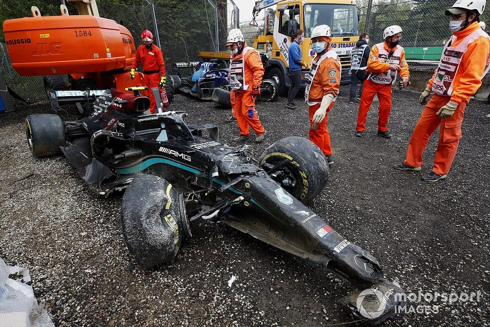 Marshals clear the damaged car of Valtteri Bottas, Mercedes W12, from the gravel trap