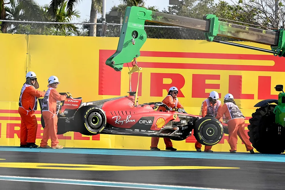 Marshals remove the damaged car of Charles Leclerc, Ferrari SF-23, from the circuit