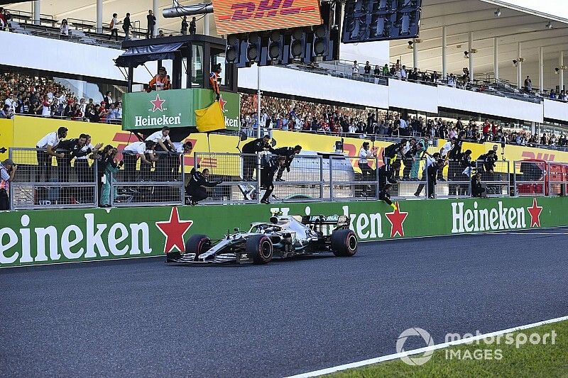 Valtteri Bottas, Mercedes AMG W10, 1st position, takes the chequered flag and passes his team on the pit wall