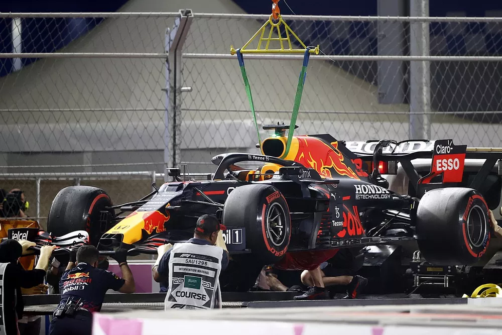 The damaged car of Max Verstappen, Red Bull Racing RB16B, is lowered onto a truck