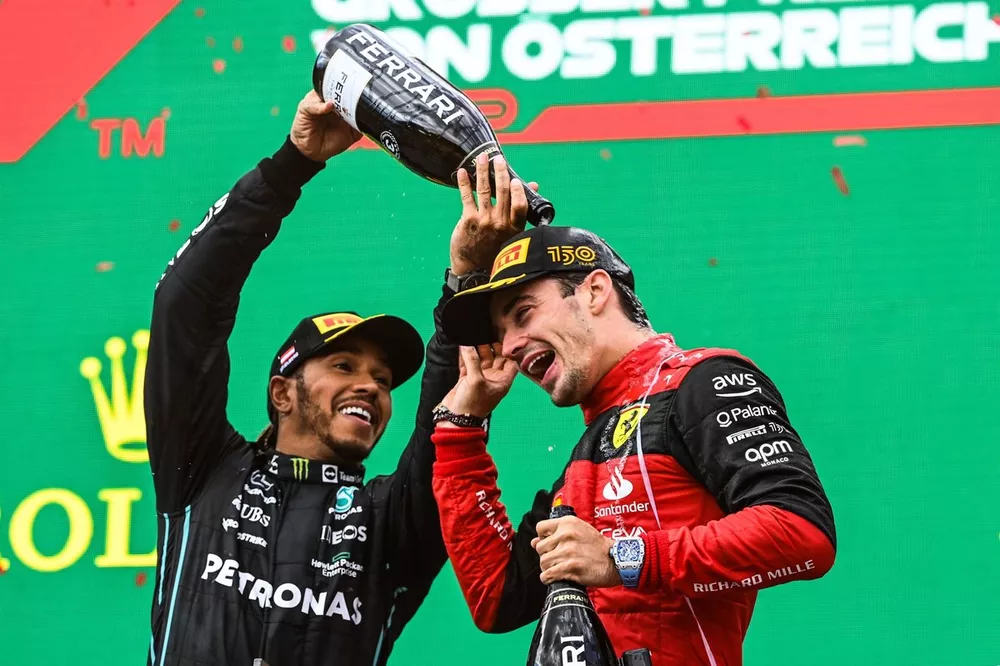Le troisième Lewis Hamilton, Mercedes-AMG, verse du Champagne sur le vainqueur Charles Leclerc, Ferrari, sur le podium