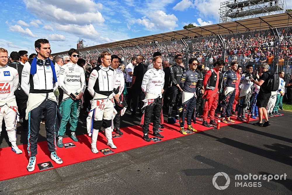 The drivers stand on the grid for the national anthem