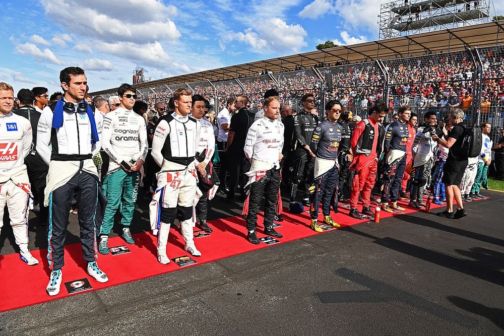 The drivers stand on the grid for the national anthem