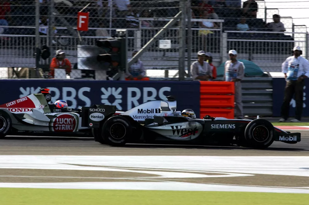 Pedro de la Rosa (ESP) McLaren Mercedes MP4/20 passes Jenson Button (GBR) BAR Honda 007.