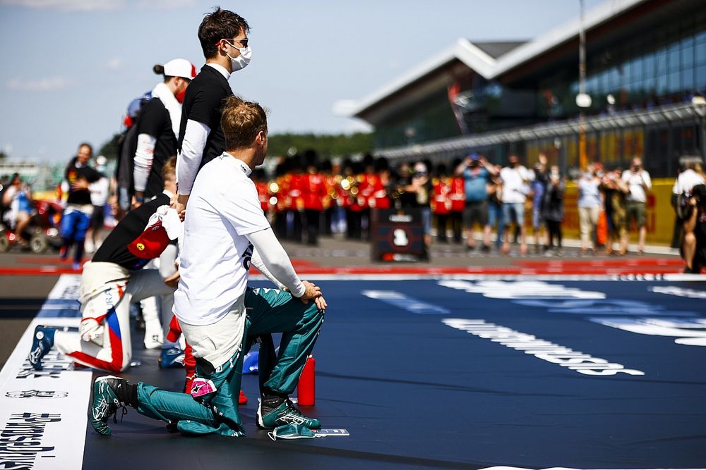 Sebastian Vettel, Aston Martin, y el resto de pilotos se ponen de pie y se arrodillan en la parrilla de salida en apoyo de la campaña Fin del Racismo