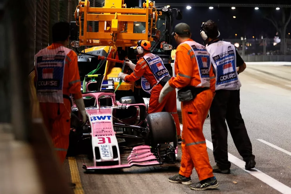 Marshals bergen de wagen van Esteban Ocon, Racing Point Force India VJM11, na zijn crash