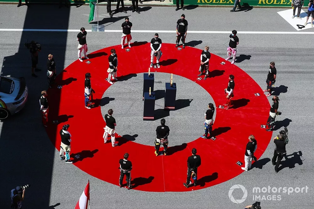 The drivers stand around the trophies prior to the start