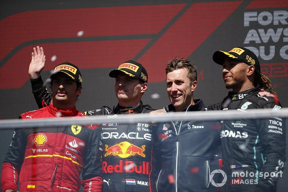 Carlos Sainz, Ferrari, 2nd position, Max Verstappen, Red Bull Racing, 1st position, the Red Bull trophy delegate and Lewis Hamilton, Mercedes-AMG, 3rd position, on the podium