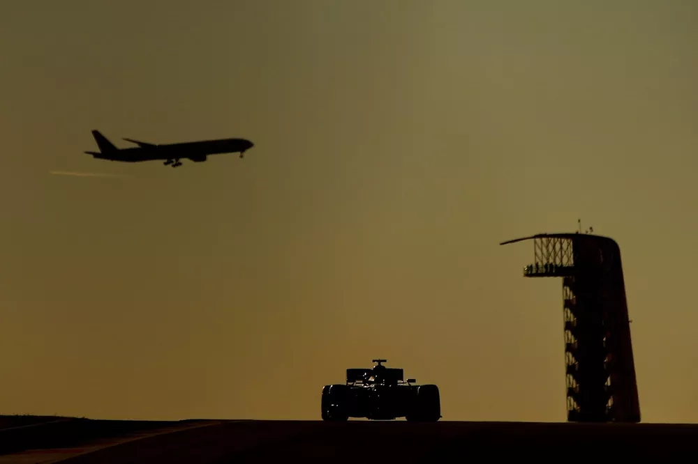 Un avion de ligne dans le ciel alors qu'une monoplace est en piste à Austin