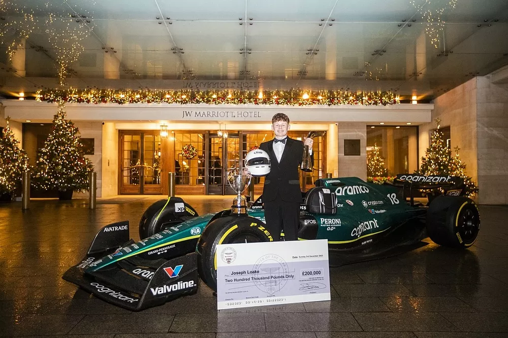 Joseph Loake celebrates with the Aston Martin F1 car after winning the Aston Martin Autosport BRDC Young Driver Award 