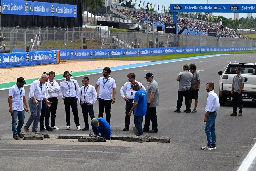 Officials repair a sinkhole on the start-finish straight.