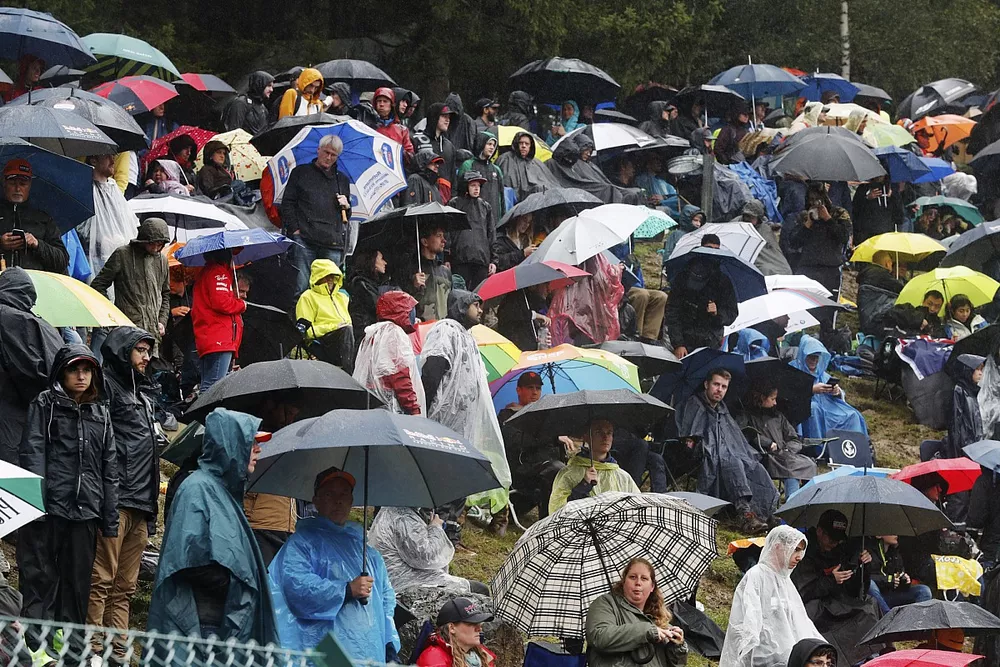 Fans under umbrellas during a red flag period