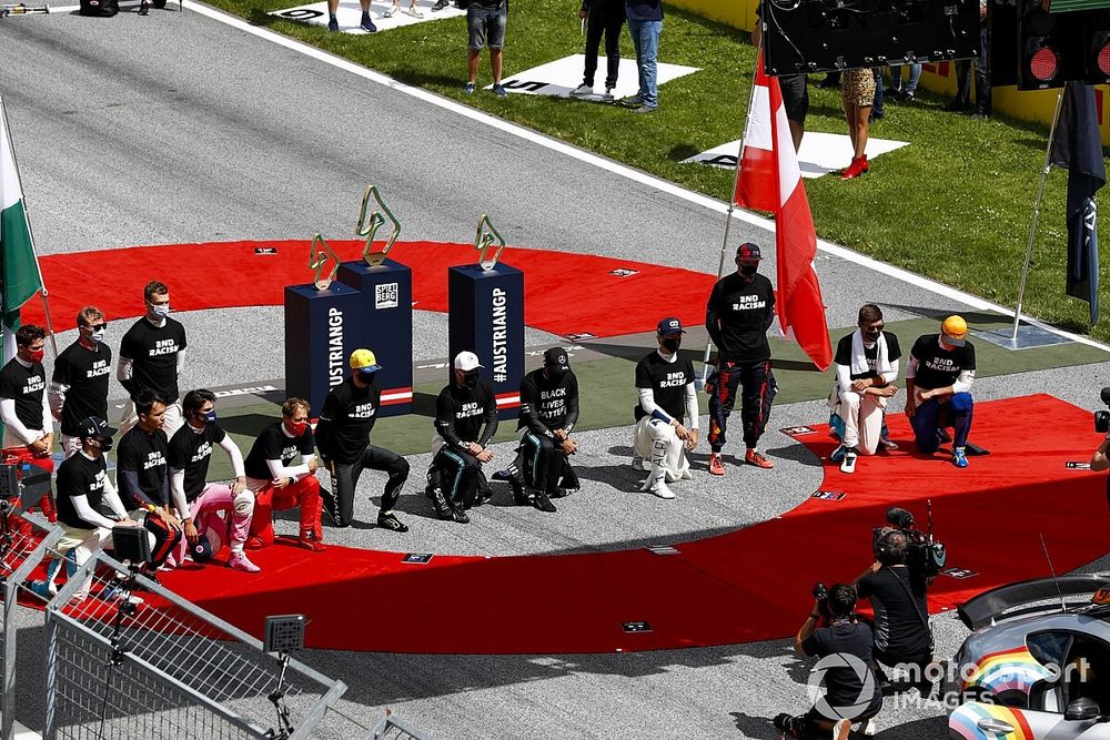 Los pilotos se arrodillan en la parrilla antes de la salida.