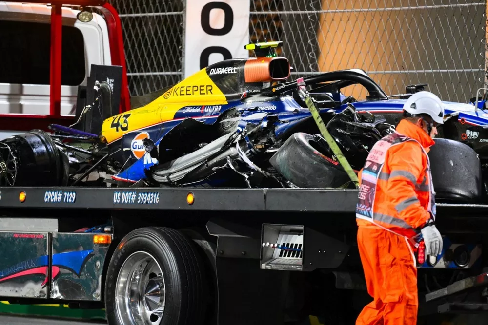 Os fiscais carregam o carro danificado de Franco Colapinto, Williams FW4