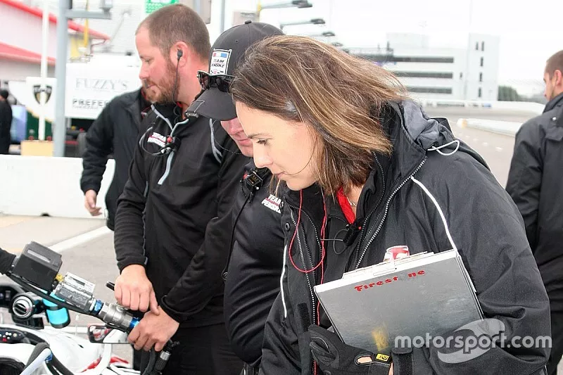 Cara Adams, chief engineer for Firestone Racing, inspects a tire on Josef Newgarden, Team Penske Chevrolet's car