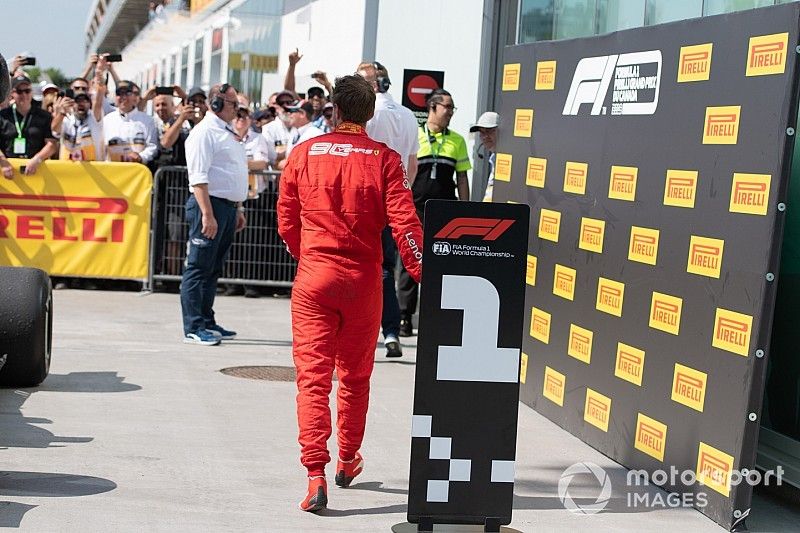 Sebastian Vettel, Ferrari, 2ª posición, se dirige al podio tras cambiar los letreros de posición delante de los coches